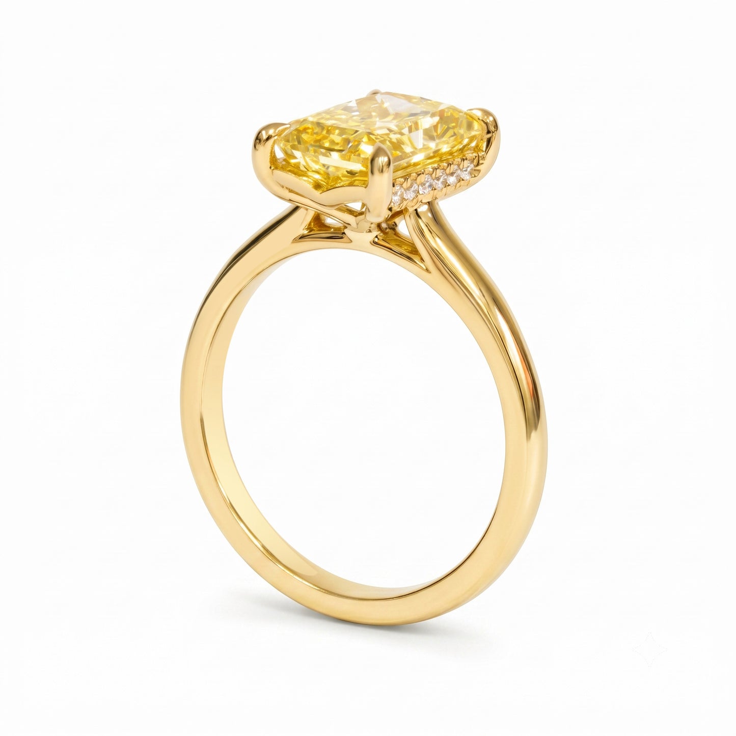 A yellow diamond engagement ring in a polished yellow gold setting, featuring a cushion-cut center stone and a halo of small accent diamonds on a clean white background.