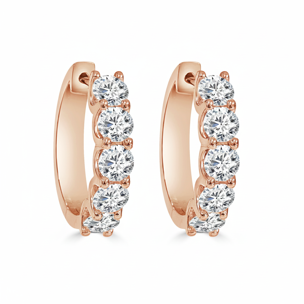 A pair of rose gold huggie hoop earrings, each adorned with a vertical row of round lab grown diamonds in a prong setting.