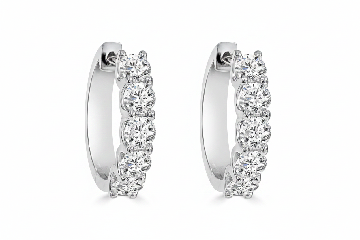 A pair of white gold hoop earrings with a curved row of clear round lab grown diamonds.