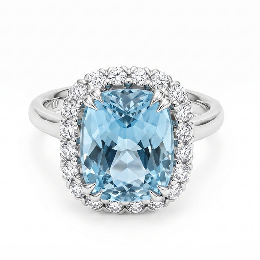 A white gold halo ring featuring a large cushion cut light blue aquamarine center stone surrounded by a double halo of small  round diamonds