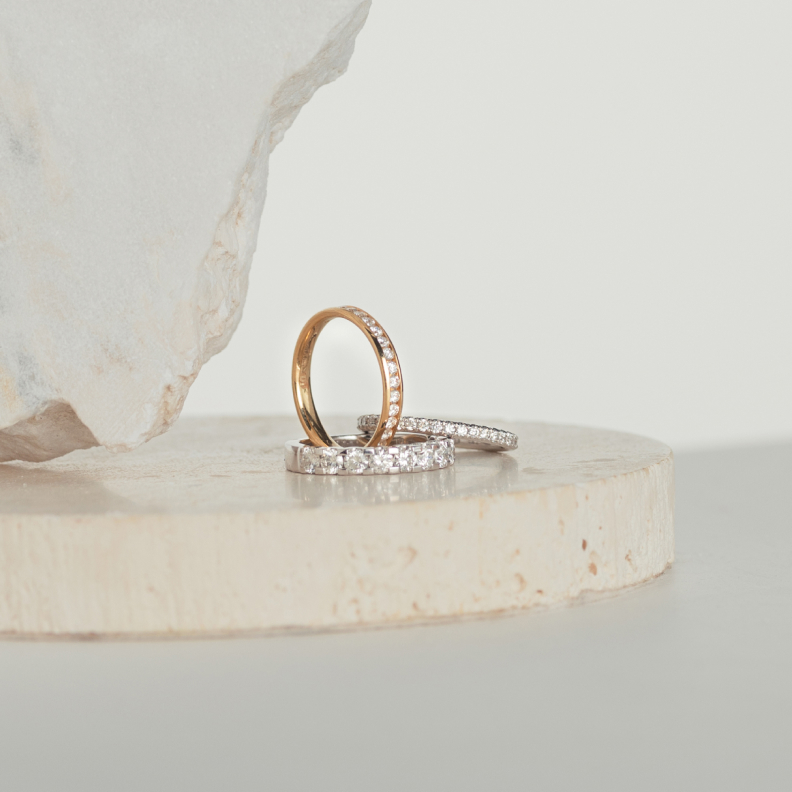 Three diamond eternity rings sitting on natural stone blocks