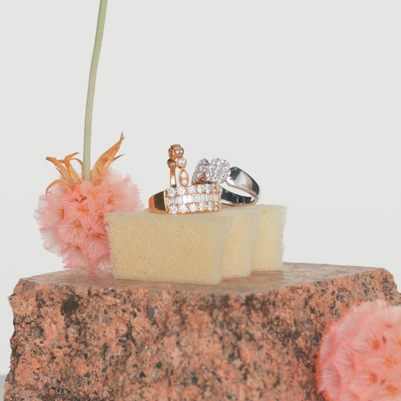 Three Diamond dress rings sit upon a terracotta stone with pink flowers