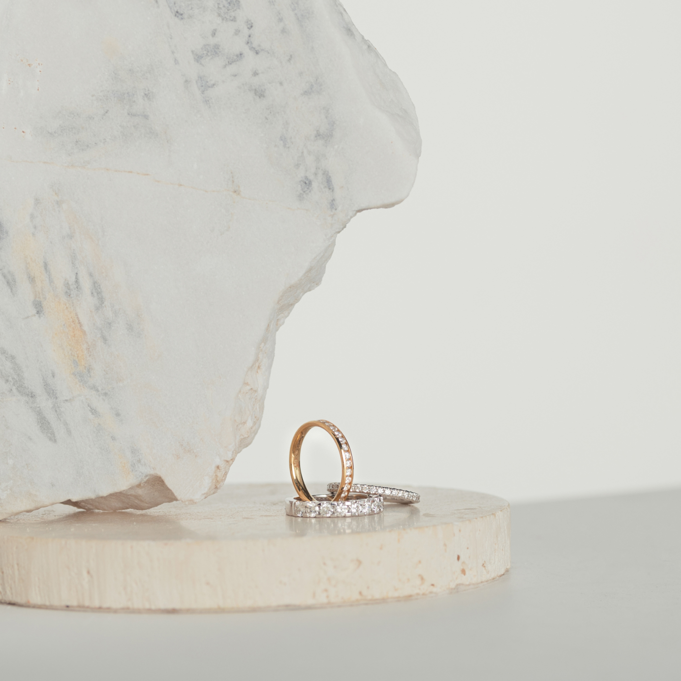 Three diamond eternity rings sitting on natural stone blocks