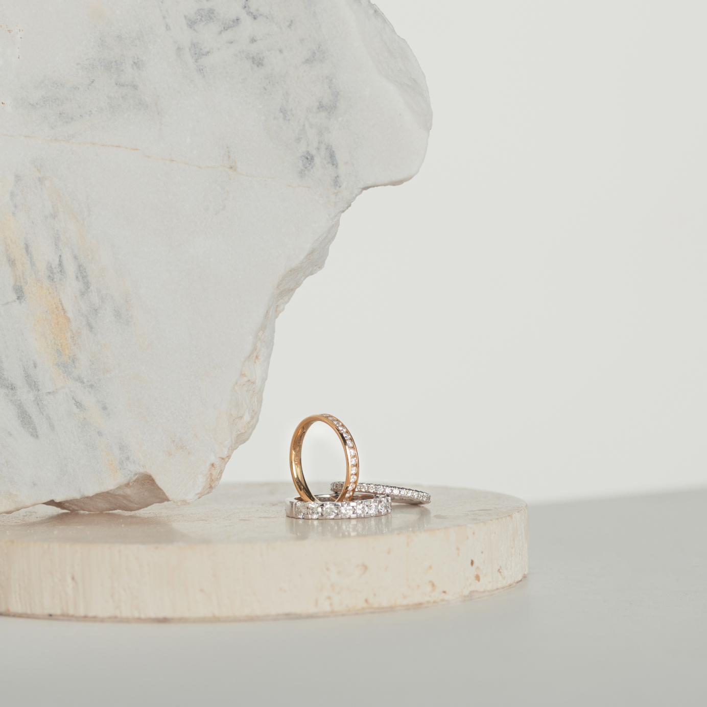 Three diamond eternity rings sitting on natural stone blocks